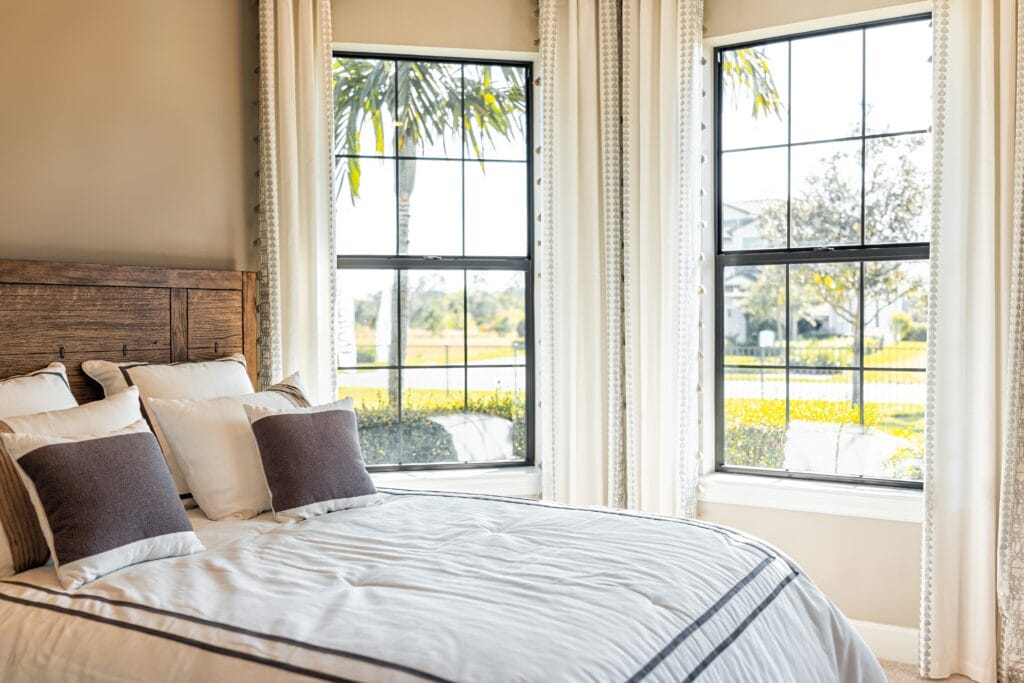 made,bed,with,decorative,pillows,in,bedroom,of,home,house