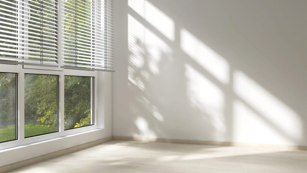 empty,room,with,white,wall,in,sunlight,from,window,blind,